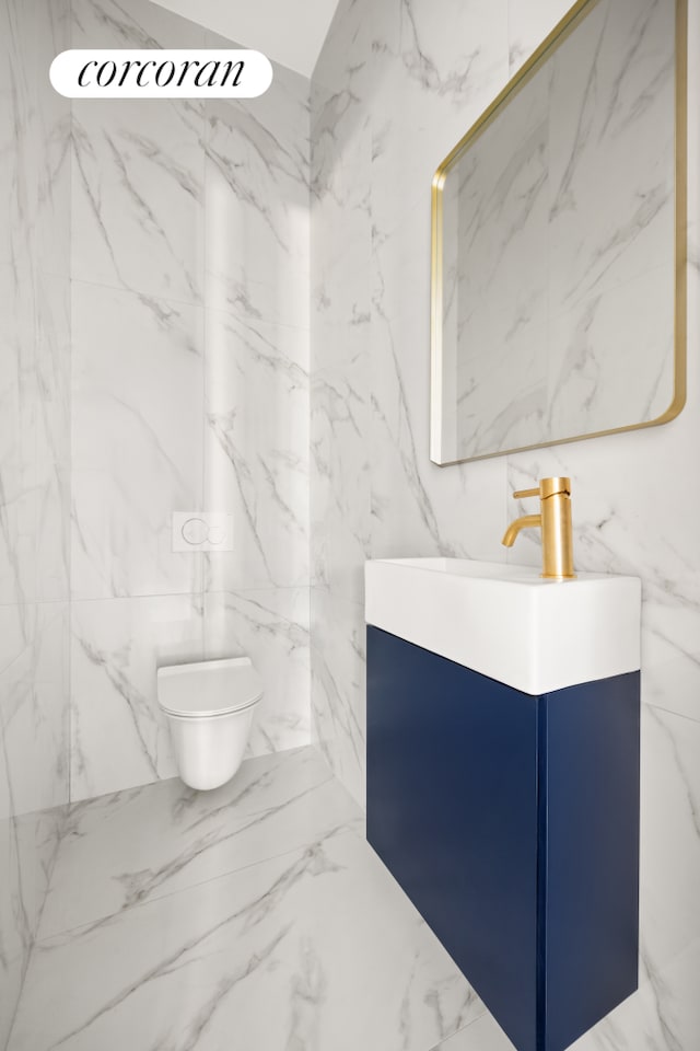 bathroom featuring stone wall, toilet, and vanity