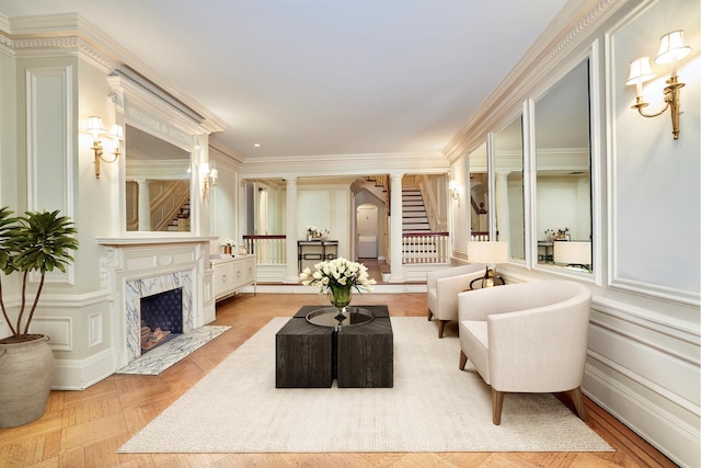 16 E 76th St, New York City, NY 10021 - living area with a decorative wall, a fireplace, stairs, and crown molding