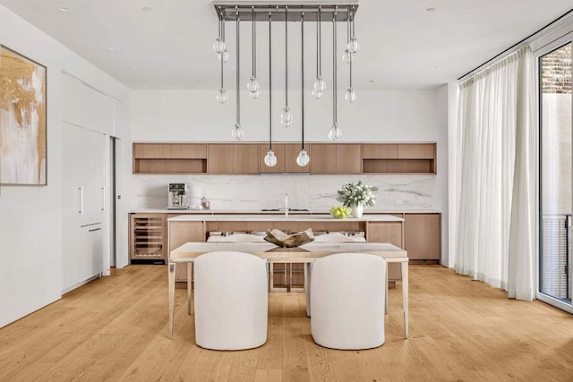 kitchen with beverage cooler, open shelves, light countertops, and decorative light fixtures