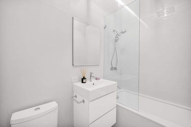 bathroom with bathtub / shower combination, vanity, and toilet