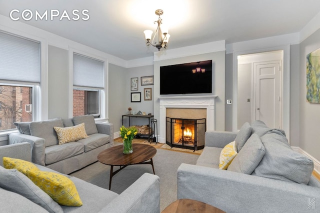 living area with a chandelier, a high end fireplace, and baseboards