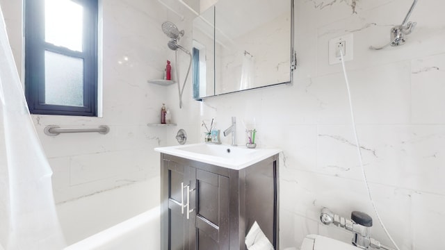 bathroom with tile walls, shower / tub combo, and vanity