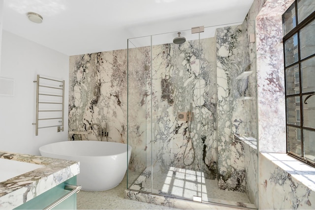 322 E 57th St Unit 12A, New York City, NY 10022 - full bathroom featuring vanity, a freestanding tub, tile walls, radiator heating unit, and a marble finish shower
