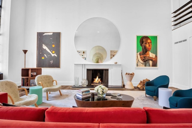 living room featuring hardwood / wood-style flooring and a towering ceiling