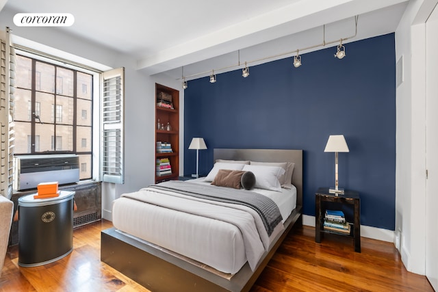 bedroom featuring track lighting and dark hardwood / wood-style floors