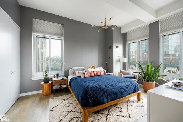 bedroom with a chandelier and light hardwood / wood-style flooring