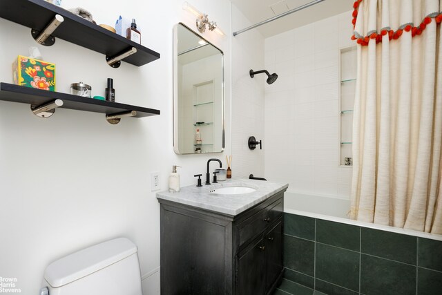bathroom featuring tiled shower / bath combo, toilet, and vanity