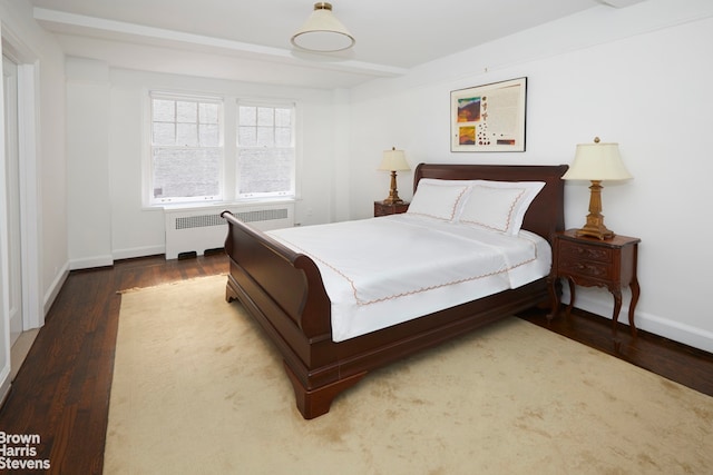 bedroom featuring hardwood / wood-style flooring and radiator heating unit