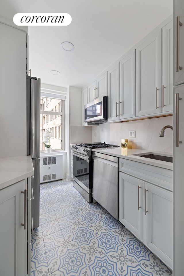 kitchen with a sink, light countertops, white cabinetry, and stainless steel appliances