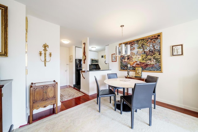 dining area with wood finished floors and baseboards