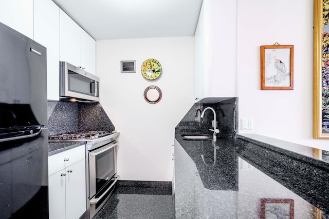 30 W 61st St Unit 21B, New York City, NY 10023 - kitchen featuring stainless steel appliances, a sink, white cabinetry, and tasteful backsplash