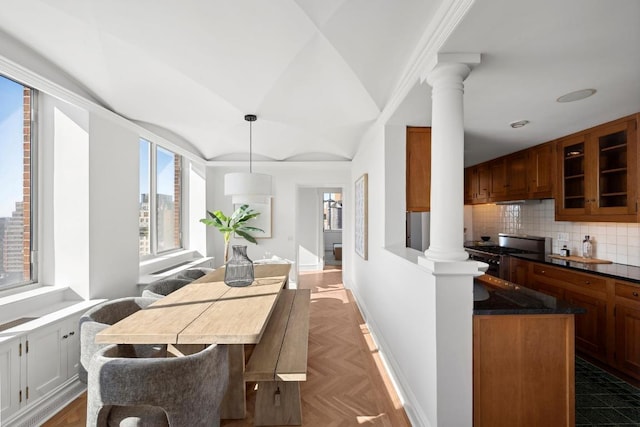 kitchen featuring backsplash, decorative light fixtures, ornate columns, range, and dark parquet flooring