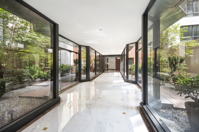 35 E 85th St Unit 2Fg, New York City, NY 10028 - corridor with healthy amount of natural light, a wall of windows, and marble tiled floors