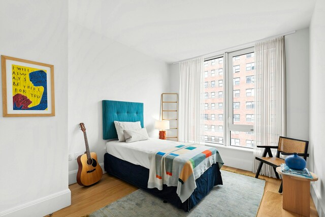 bedroom with baseboards and wood finished floors