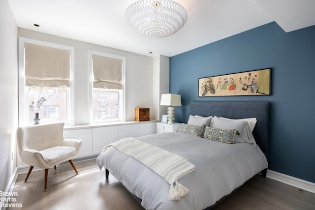 bedroom featuring hardwood / wood-style flooring and an inviting chandelier