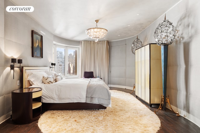 bedroom featuring dark wood-type flooring, baseboards, and a chandelier