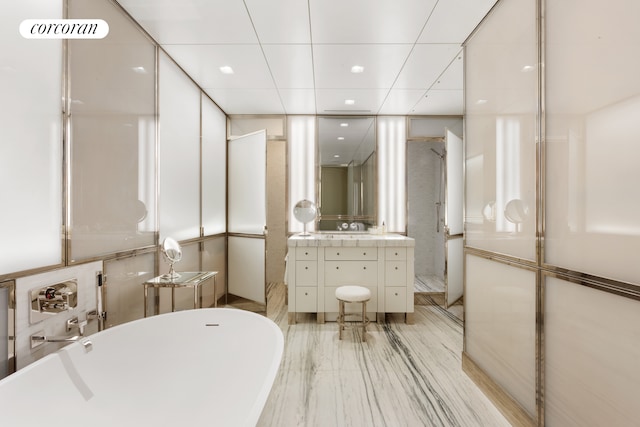 bathroom with a soaking tub and vanity