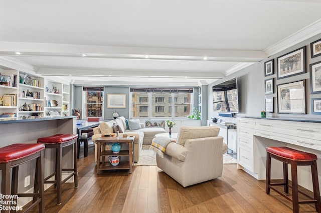 living area featuring crown molding, beam ceiling, and wood finished floors