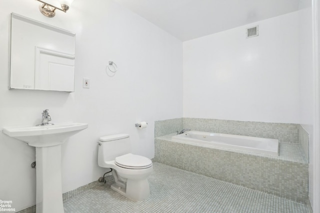 bathroom featuring sink, toilet, tiled bath, and tile patterned flooring