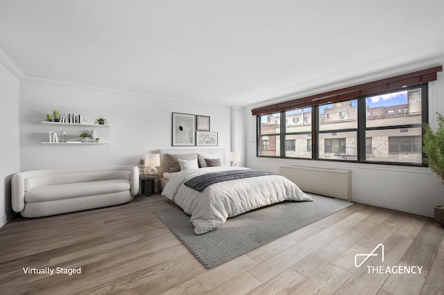 bedroom featuring wood finished floors and ornamental molding