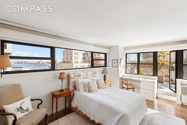 bedroom with a water view and light hardwood / wood-style floors