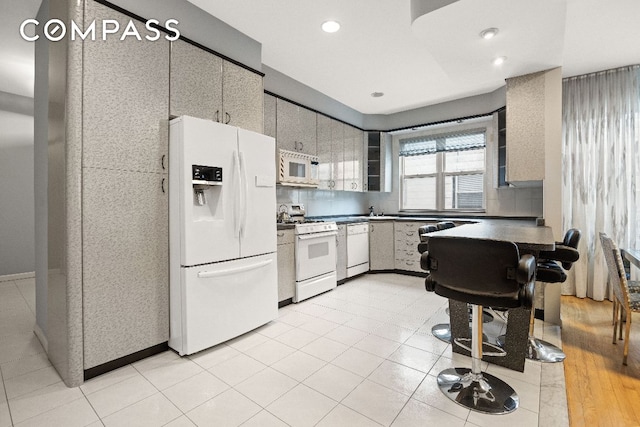 kitchen featuring dark countertops, white appliances, backsplash, and recessed lighting