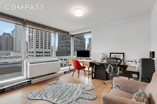 office area featuring radiator heating unit, a wall of windows, and hardwood / wood-style flooring