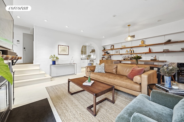 living area featuring arched walkways, visible vents, and recessed lighting