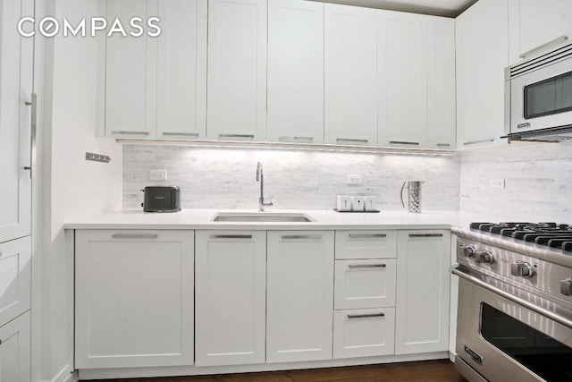 kitchen with sink, stainless steel appliances, tasteful backsplash, and white cabinets