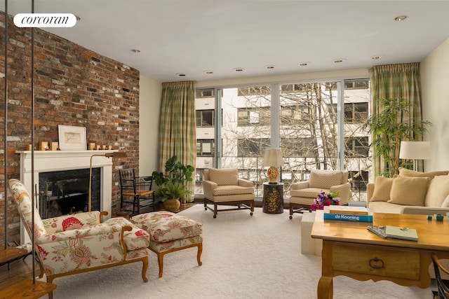 living area featuring a fireplace, carpet floors, and a healthy amount of sunlight