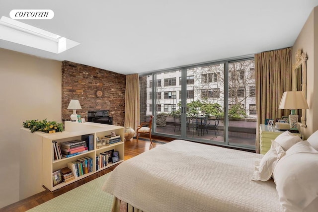 bedroom featuring a skylight, access to exterior, wood finished floors, and visible vents