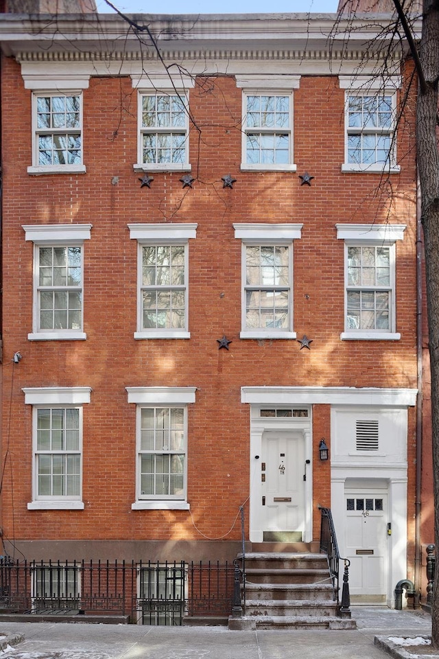 46 Perry St, New York City, NY 10014 - multi unit property with brick siding, entry steps, and fence