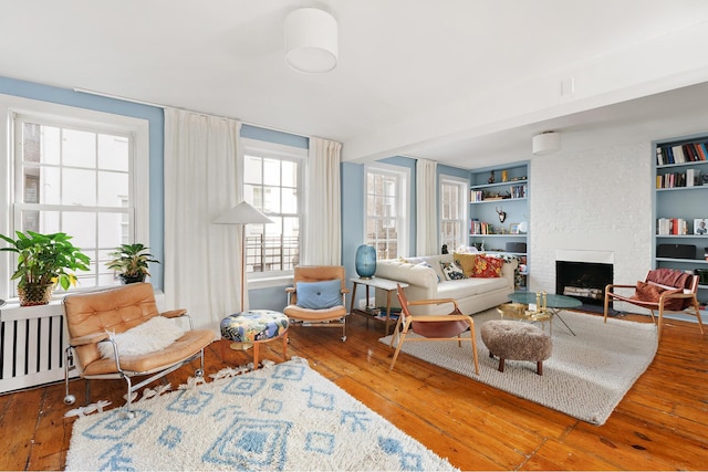 46 Perry St, New York City, NY 10014 - living room with a fireplace, built in shelves, and hardwood / wood-style floors