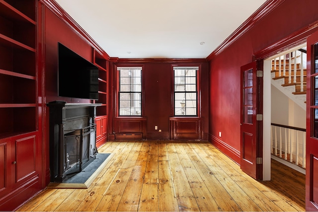 46 Perry St, New York City, NY 10014 - unfurnished living room with crown molding, light wood-style floors, a fireplace, a baseboard heating unit, and stairs