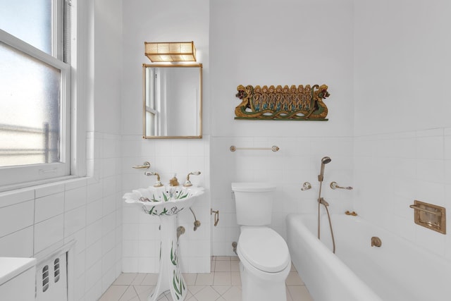 14 Sutton Pl S Unit 13F, New York City, NY 10022 - bathroom with a garden tub, plenty of natural light, tile walls, wainscoting, and tile patterned flooring