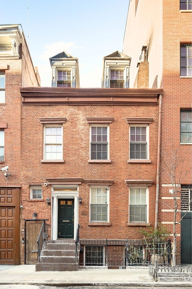 view of front facade featuring entry steps and brick siding