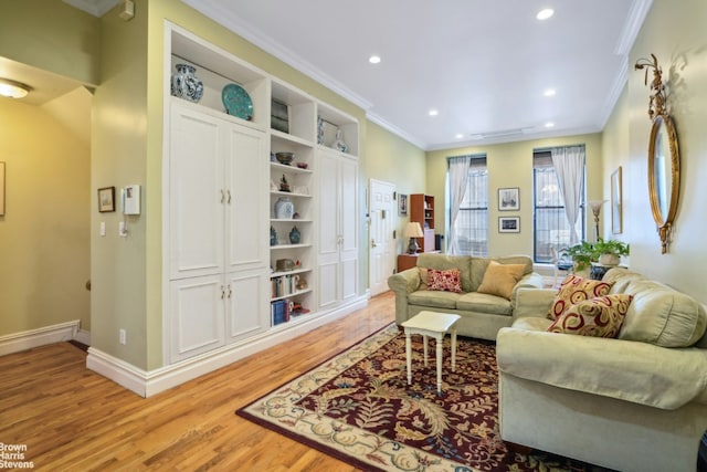 living area with ornamental molding, recessed lighting, light wood-style flooring, and baseboards