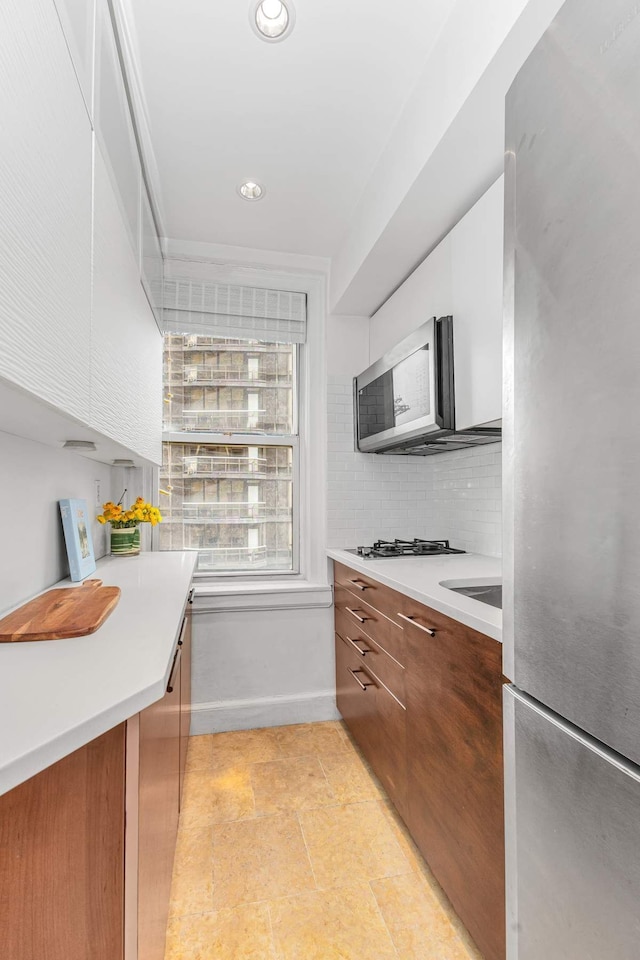 400 E 59th St Unit 9G, New York City, NY 10022 - kitchen featuring appliances with stainless steel finishes, modern cabinets, light countertops, white cabinets, and recessed lighting
