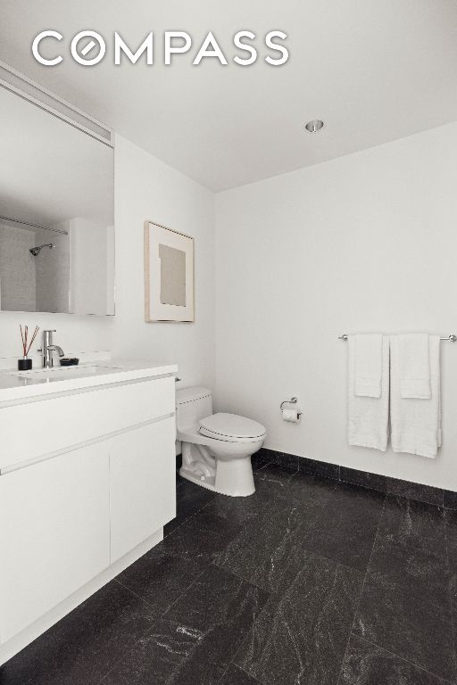 full bathroom featuring vanity, toilet, and baseboards