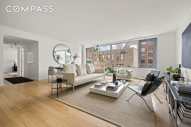 living room with baseboards and light wood-style floors