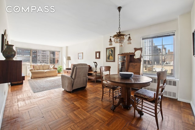 dining space with radiator heating unit and a view of city