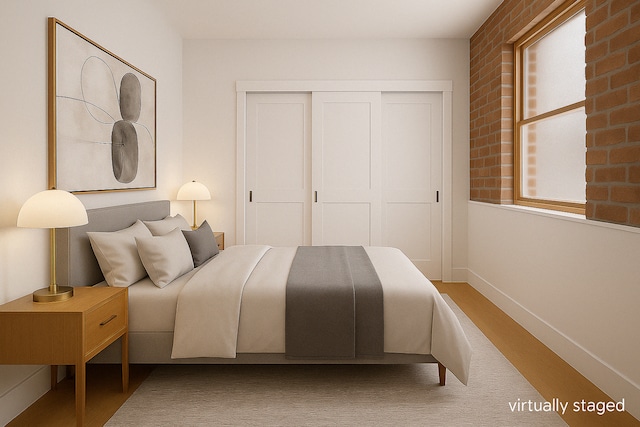 bedroom with a closet, baseboards, and wood finished floors
