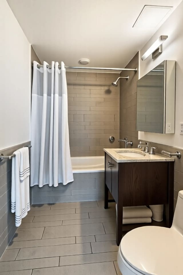 full bathroom with toilet, tiled shower / bath combo, and vanity