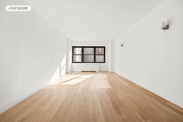 empty room featuring light wood-style floors, baseboards, and visible vents