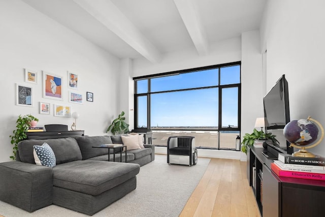 living room featuring beamed ceiling and light hardwood / wood-style floors