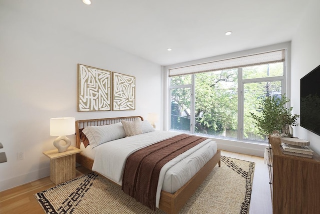 bedroom featuring recessed lighting, multiple windows, light wood-style flooring, and baseboards