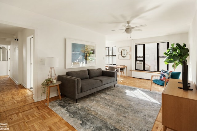 living room with ceiling fan, light parquet floors, and radiator heating unit