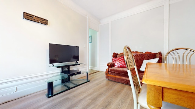 living room featuring light hardwood / wood-style floors and crown molding