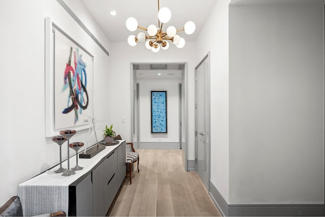 215 Sullivan St Unit 4A, New York City, NY 10012 - hallway featuring light wood finished floors, a chandelier, and baseboards