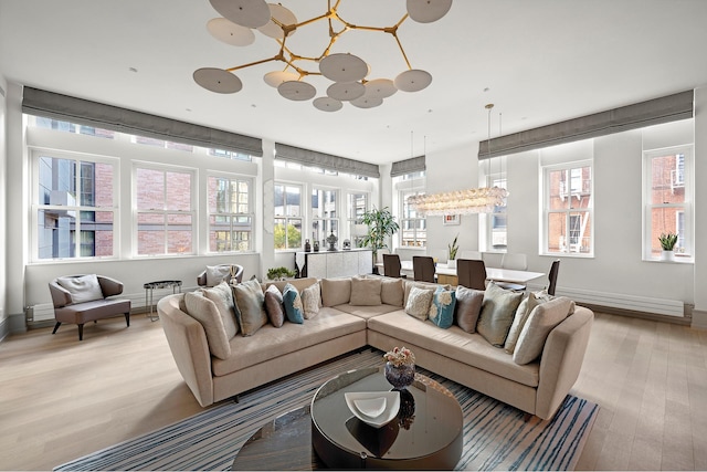 215 Sullivan St Unit 4A, New York City, NY 10012 - living area featuring light wood-type flooring, plenty of natural light, baseboards, and a chandelier